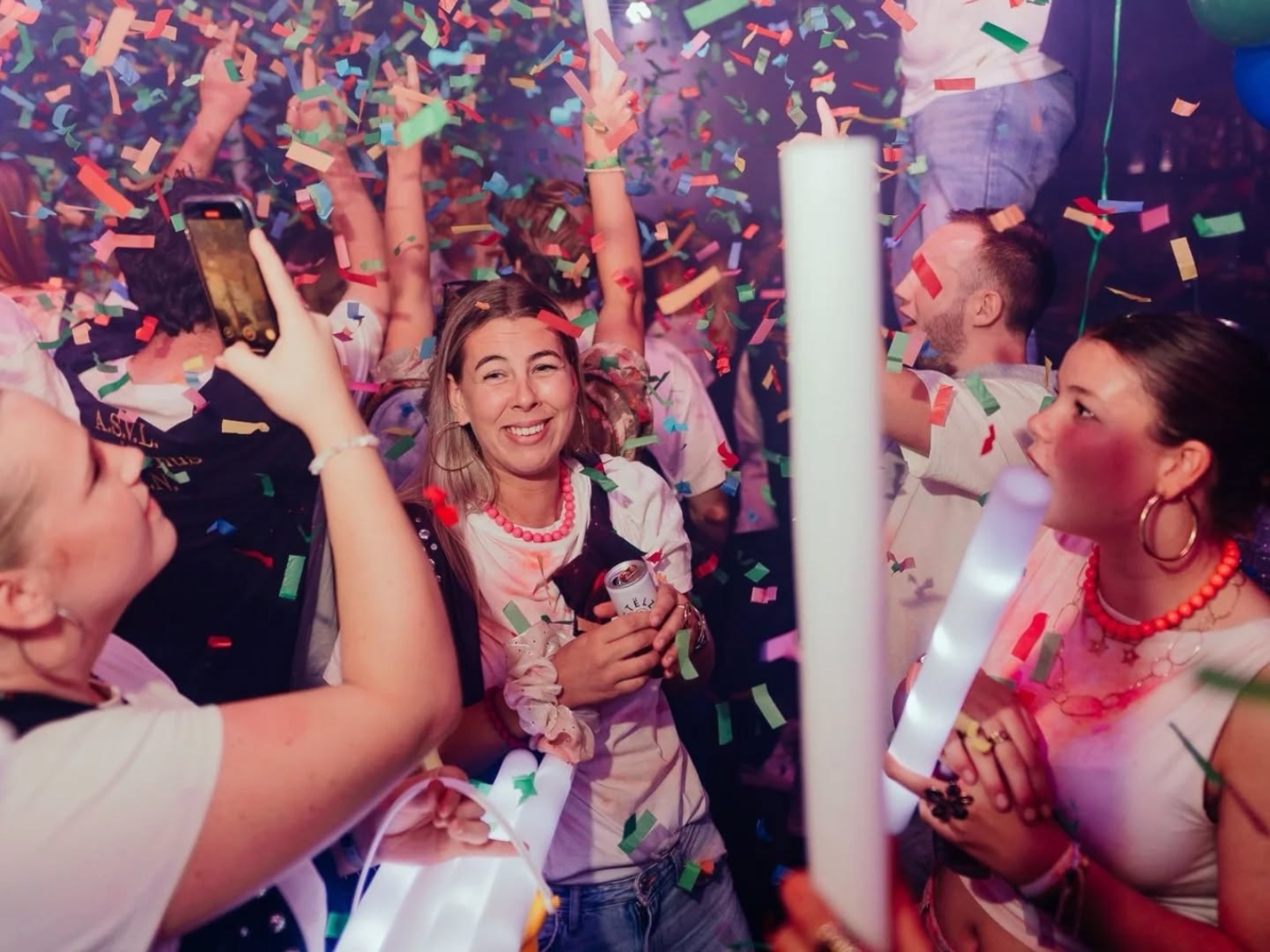 Party crowd under confetti with glow sticks at Bar Bascule